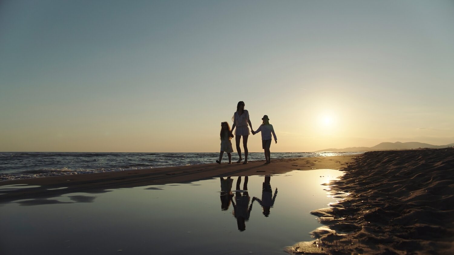 Gezin zonsondergang strand vakantie