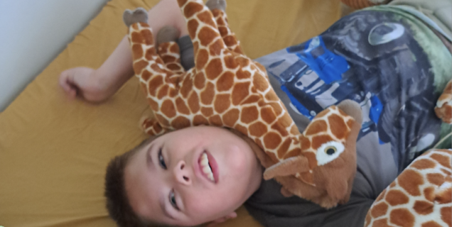 Nathan liggend met giraf